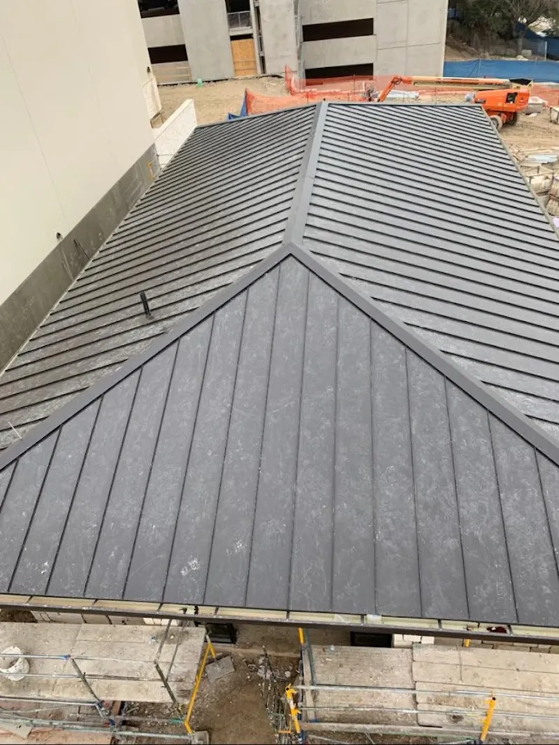 Commercial metal roof construction with crane equipment in Kapaa